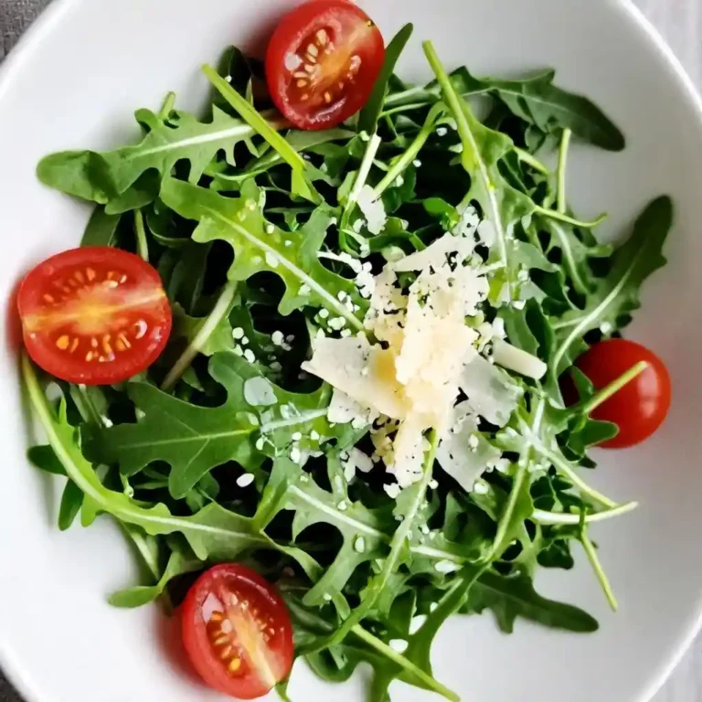 Lemon Arugula Salad 1 Fresh lemon arugula salad in white bowl with parmesan and tomatoes